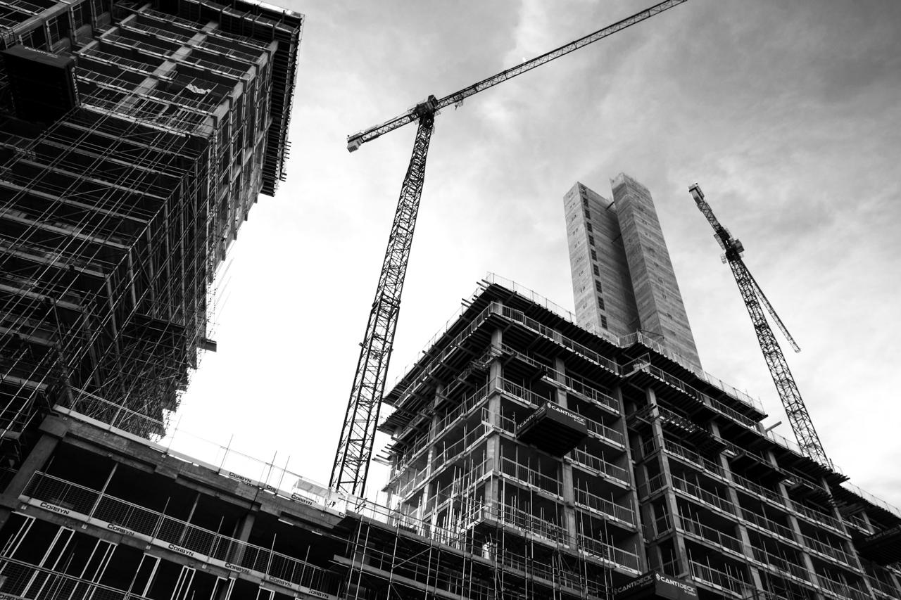 Black and white view of a construction site and tower cranes